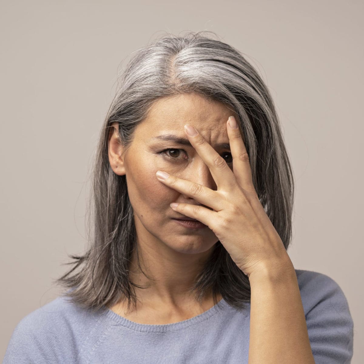 sad patient holding her face